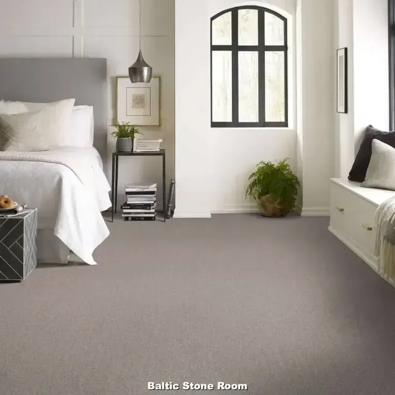 Bedroom with gray carpet, a bed, a window, and a reading nook.