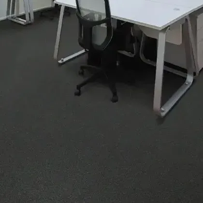 Office space with black flooring, a white desk, and a black office chair.