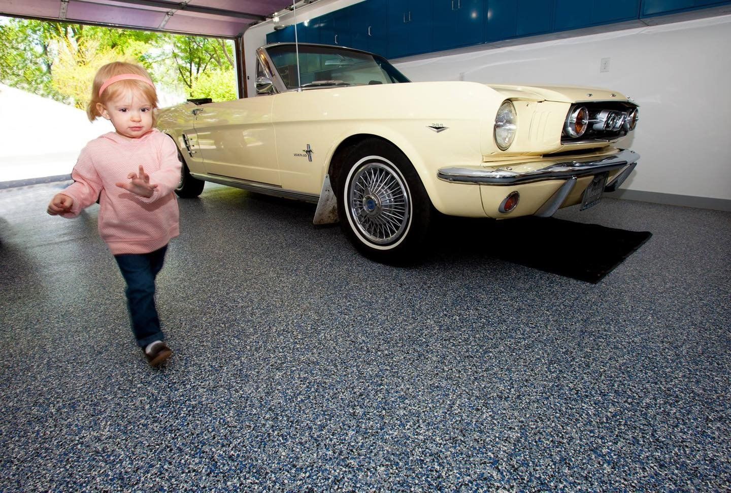 A kid and a car inside a garage