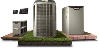 Three air conditioners are sitting on top of a piece of grass.