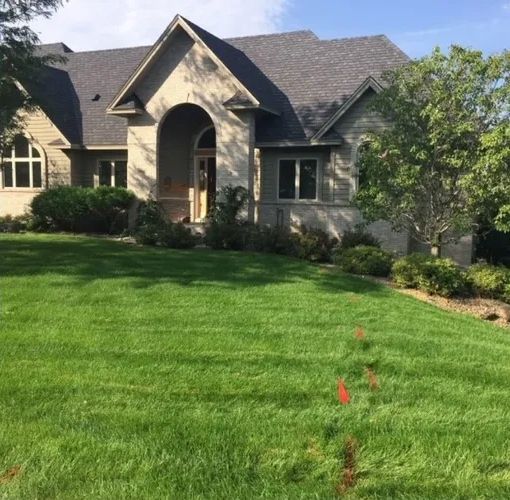 A large house with a lush green lawn in front of it