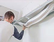 Man cleaning duct