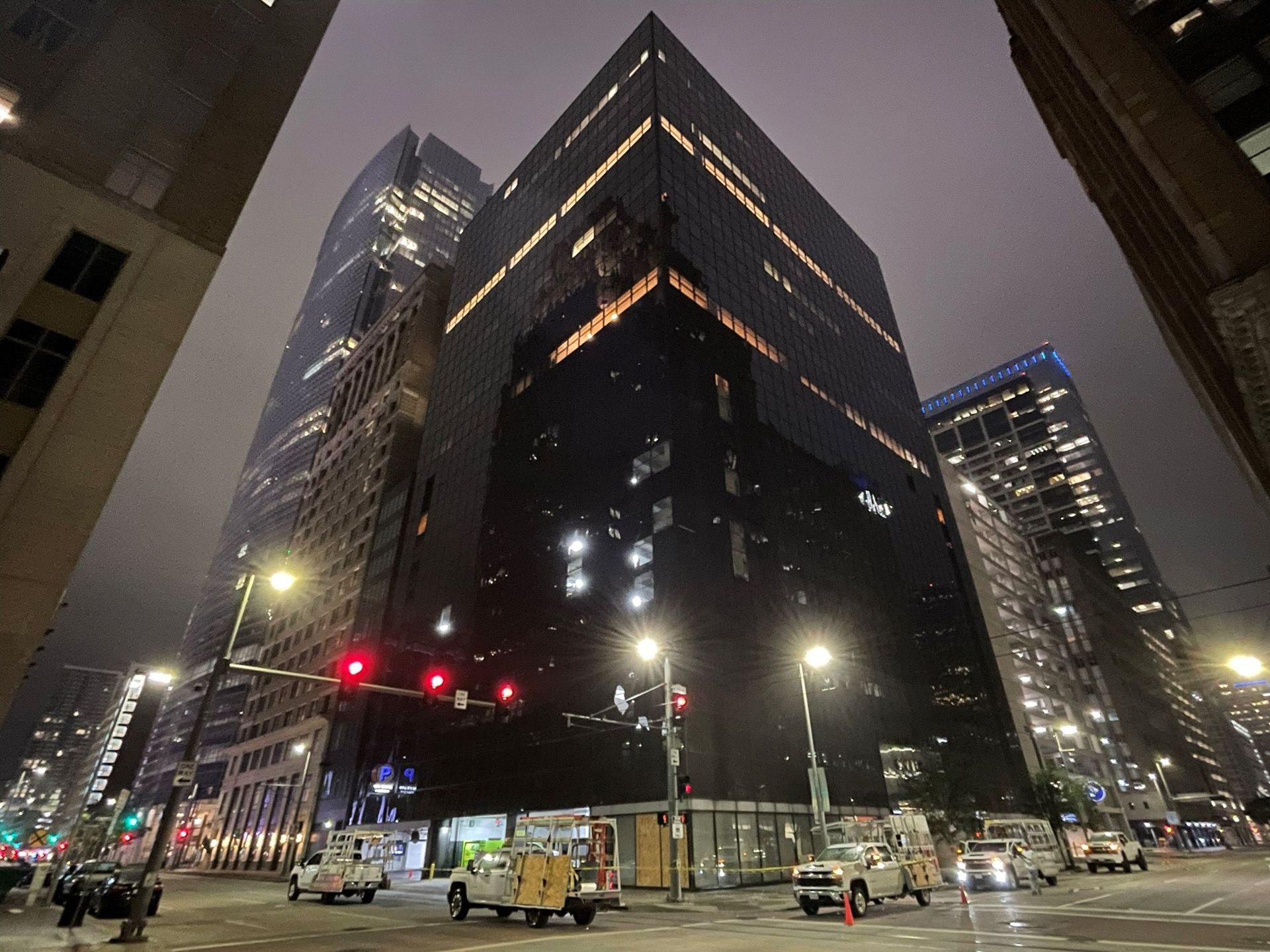A city street at night with a large building in the background