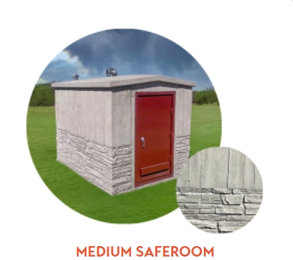 Medium concrete storm shelter with red door, stone accents, set in a grassy field.