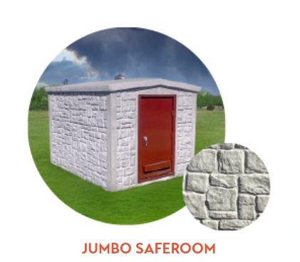 Jumbo safe room, light gray concrete block exterior, red door, set in a grassy area, small close-up of textured wall.