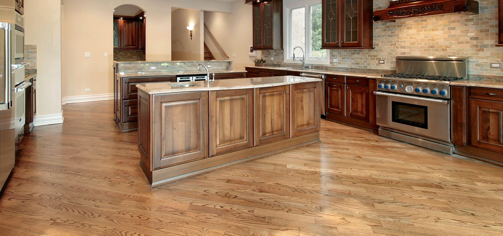 Spacious modern kitchen with wood cabinets, granite island, and stainless steel appliances