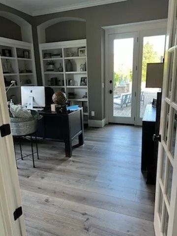 Home office with built-in shelves, desk, and glass doors to a patio.