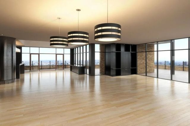 Empty modern living room with light wood floors, black accents, and large windows overlooking a city view
