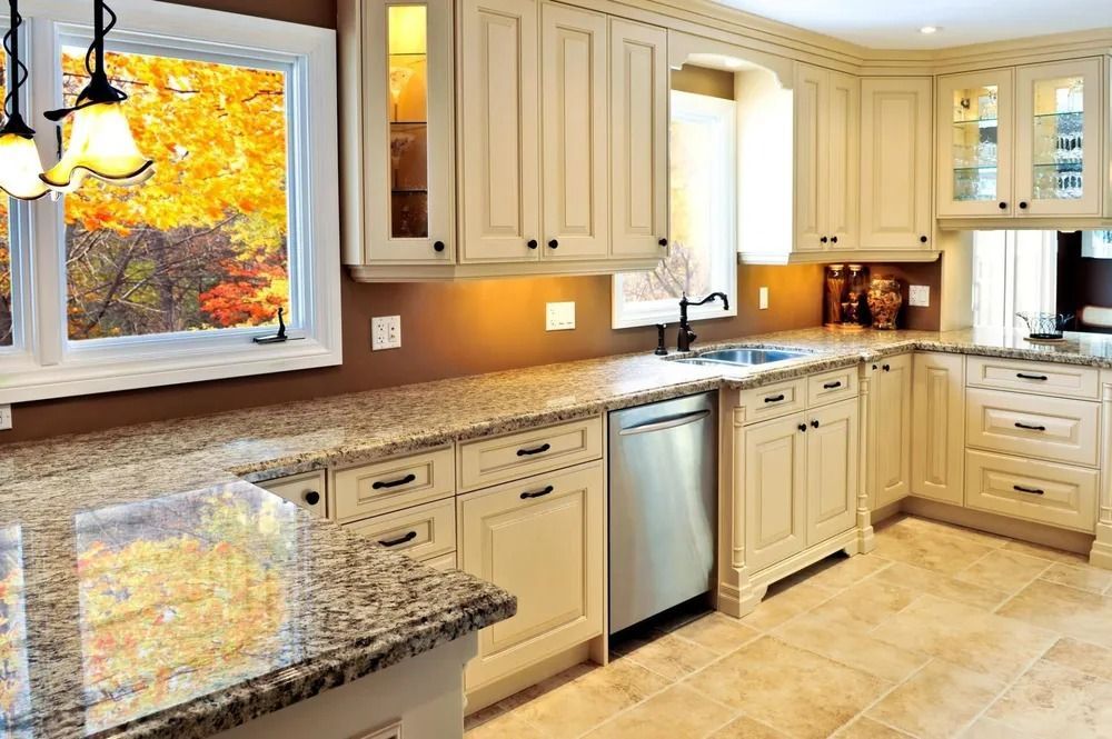 Bright modern kitchen with cream cabinets, granite counters, and a window over the sink
