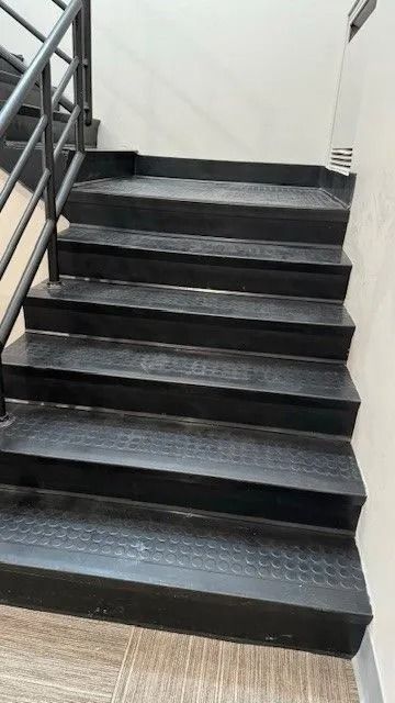 Black metal staircase with handrails and white walls indoors