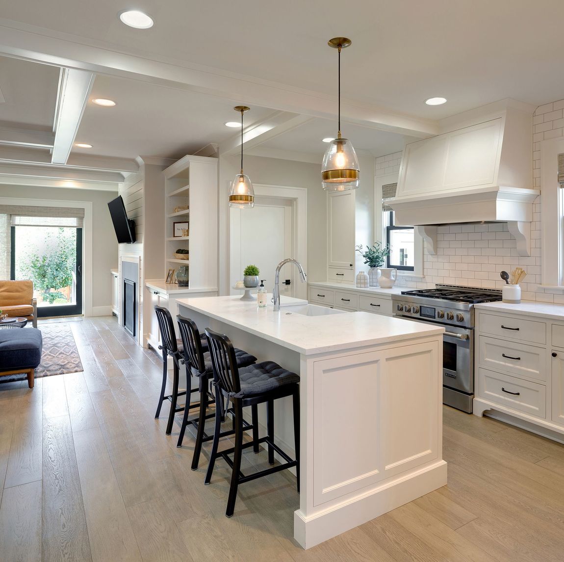 Modern white kitchen with grey island and stainless steel appliances.