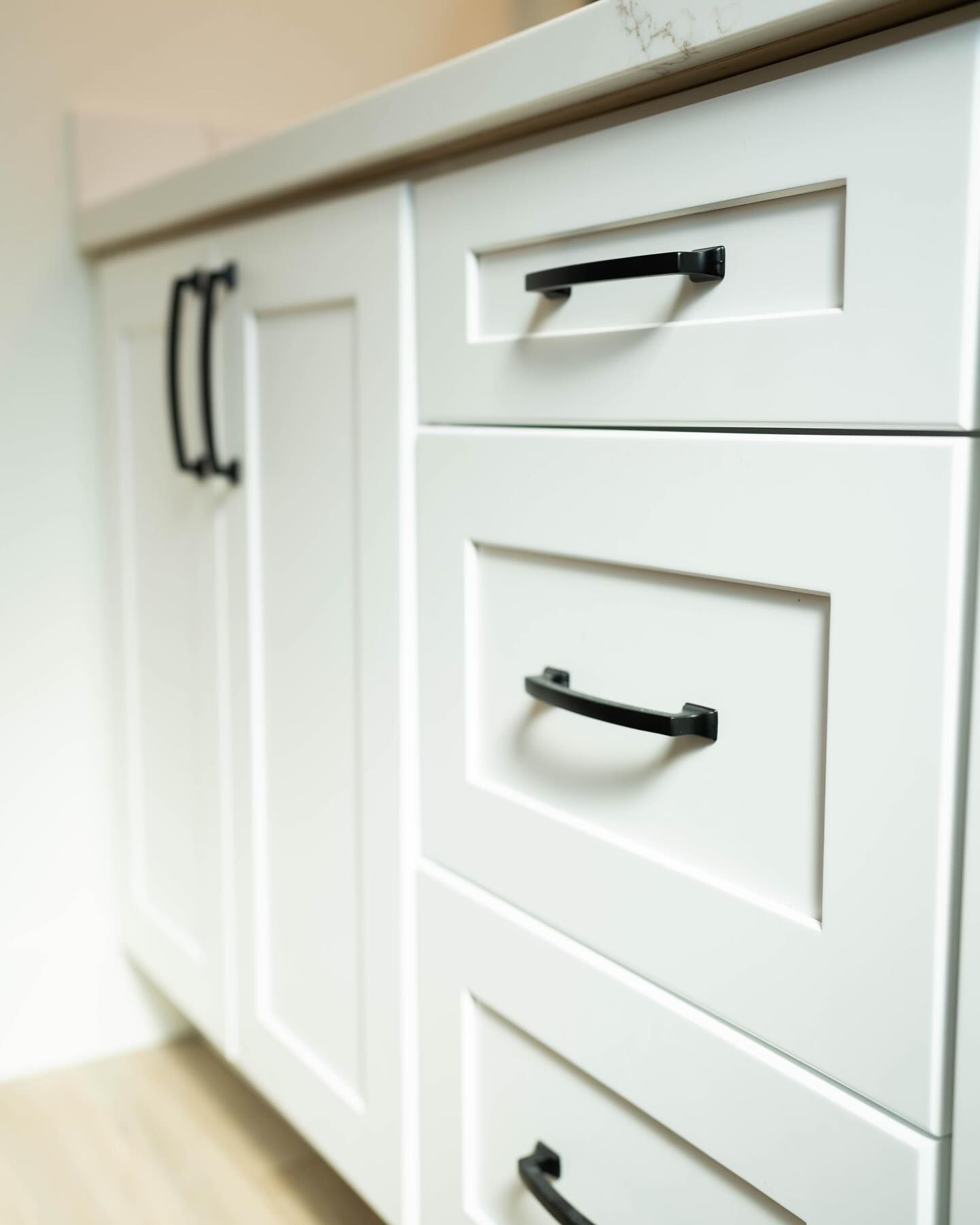 White bathroom cabinets with black handles.