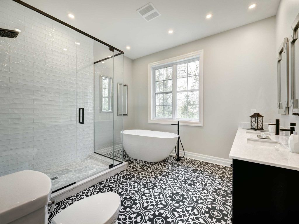 Bathroom with black and white patterned floor, white shower, tub, and vanity.