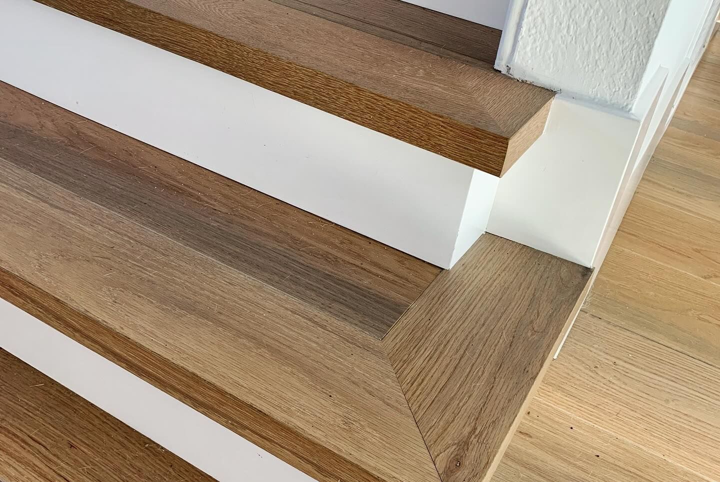 Wooden steps with white risers. Transition from stairs to landing.
