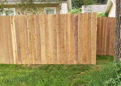 Wooden privacy fence in a grassy yard.