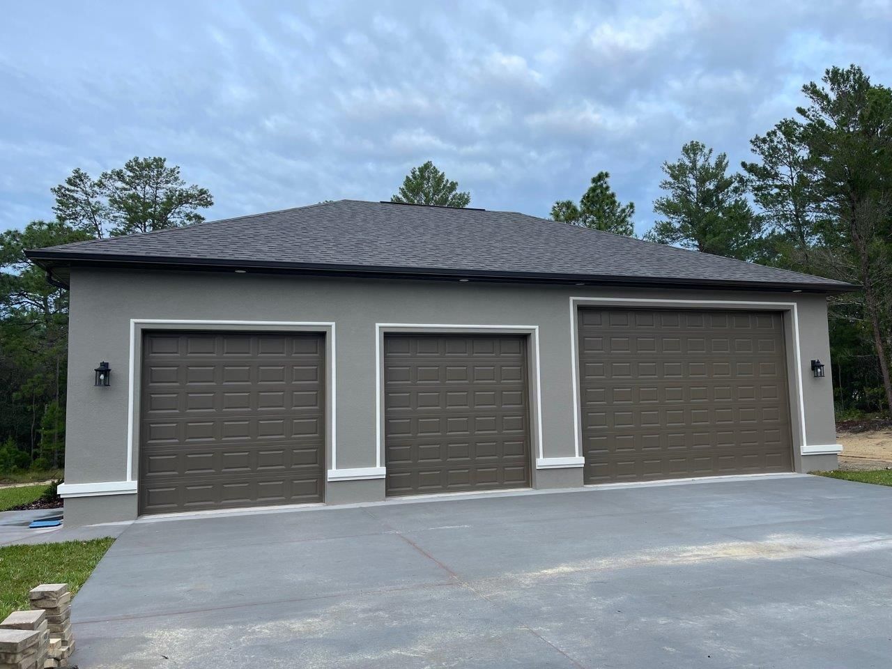 A garage with three garage doors and a gray roof