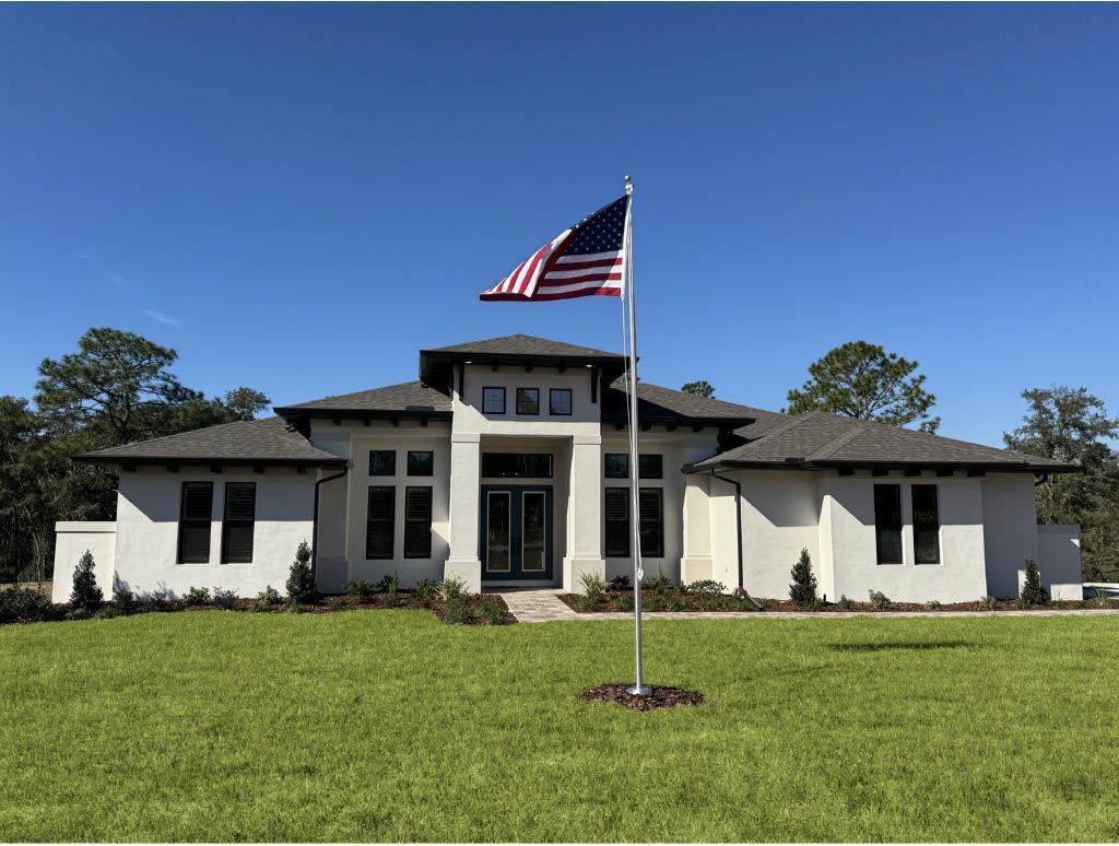 A large white house with an American flag flying in front of it.