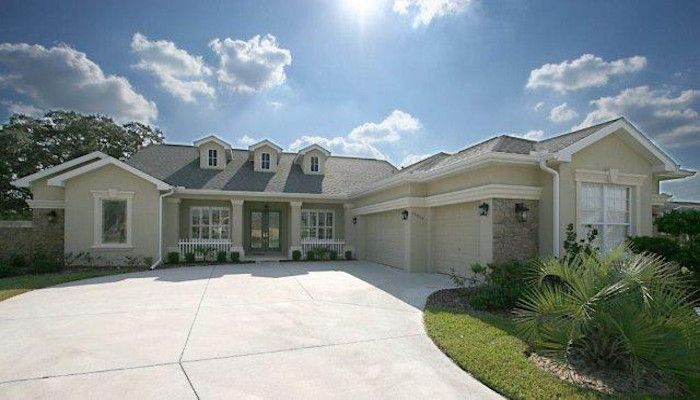 A large white house with a concrete driveway in front of it