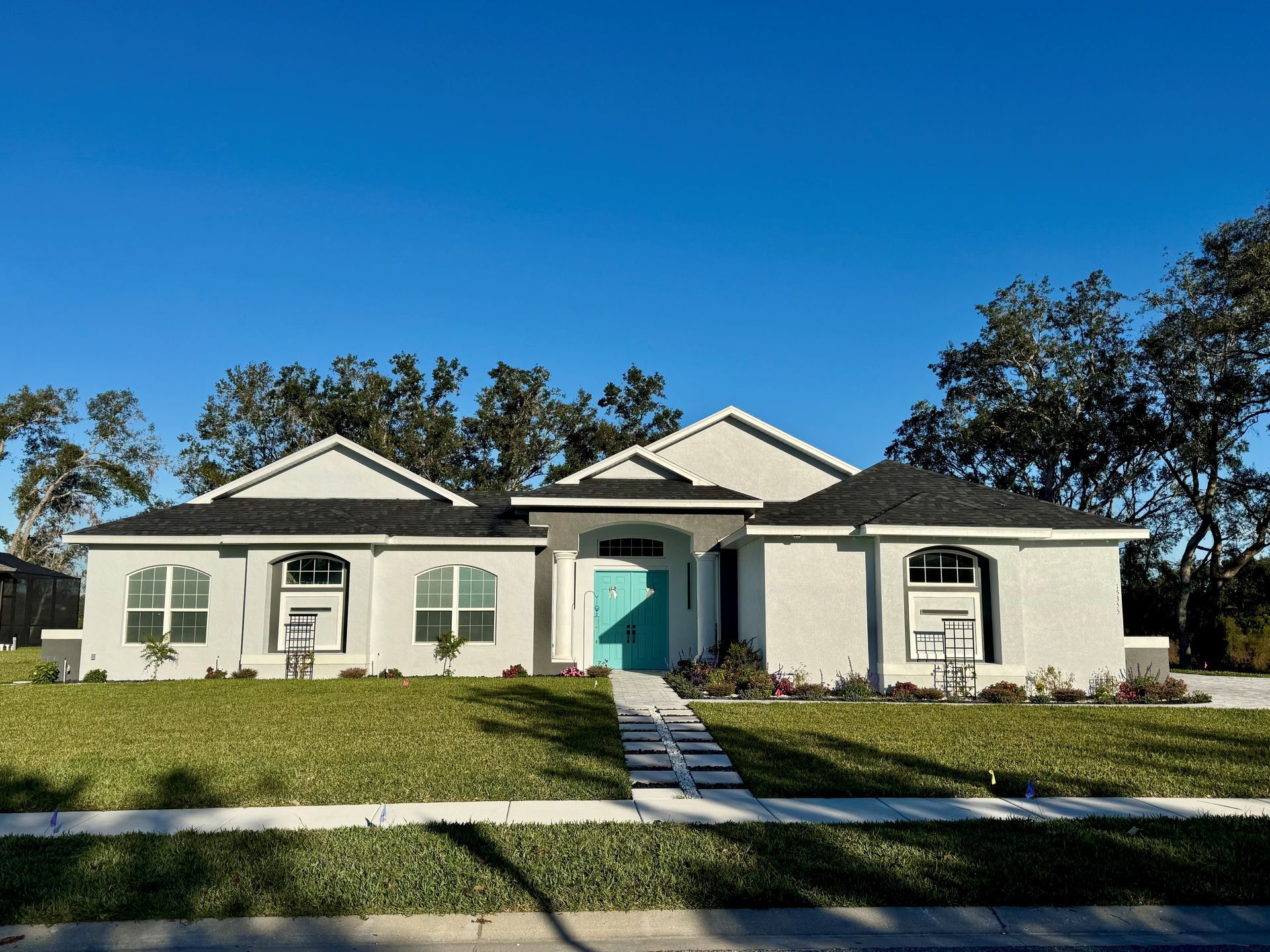 A white house with a blue door and a blue sky in the background