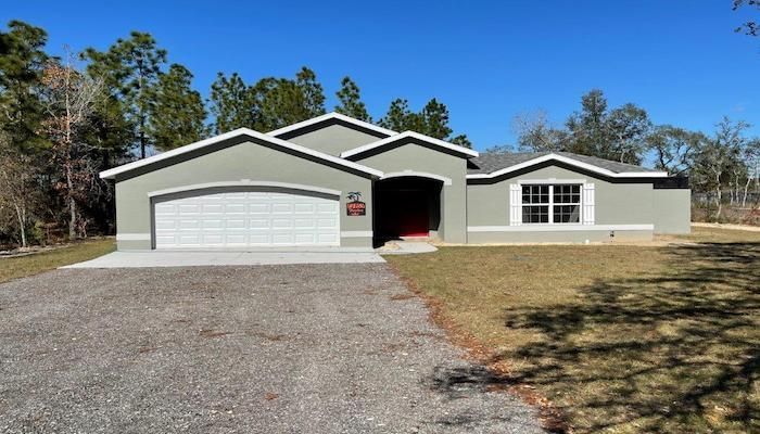 A house with a garage and a driveway in front of it.