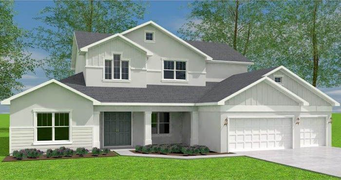 A white house with a black roof is sitting on top of a lush green lawn.