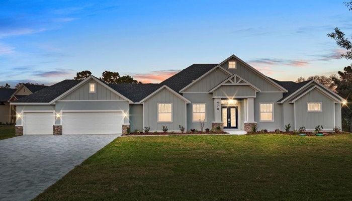 A large white house with a large driveway in front of it