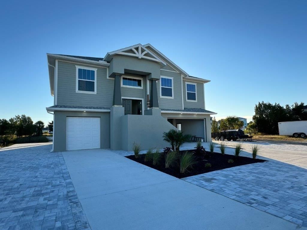 A large grey house with a white garage door