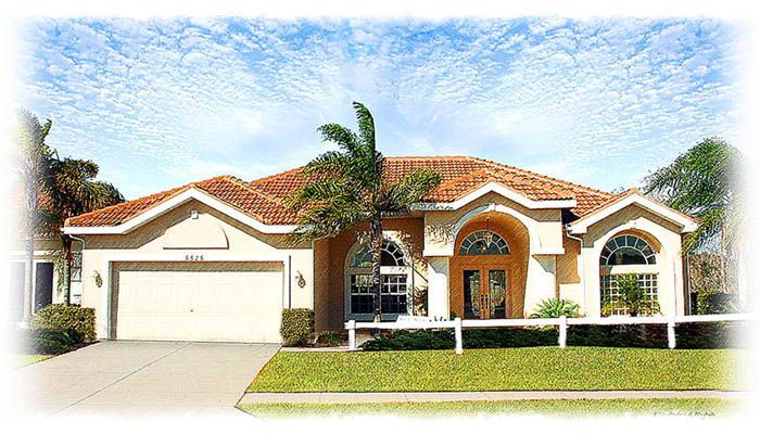 A large house with a red tile roof and a white garage door.