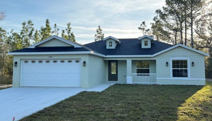 A white house with a blue roof and a white garage door.