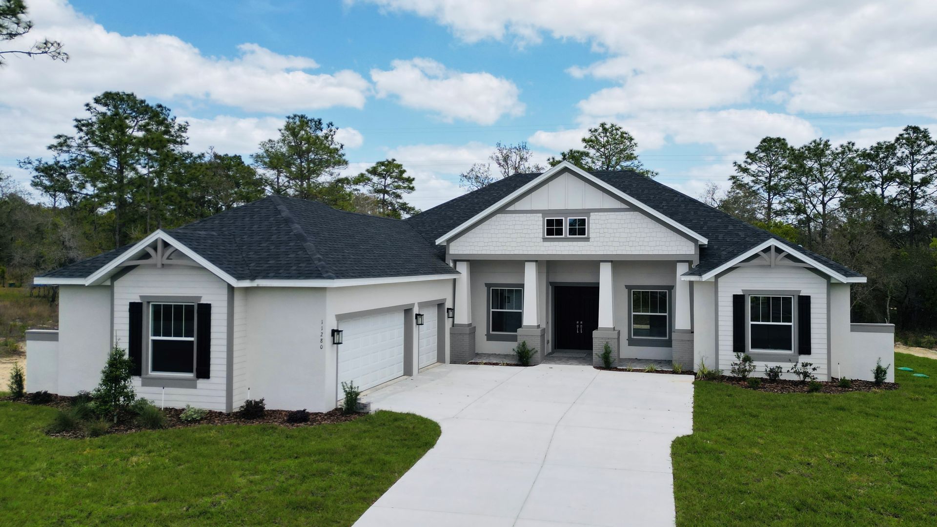 A large white house with a black roof and black shutters