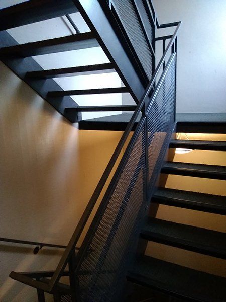 A black metal staircase with a mesh railing