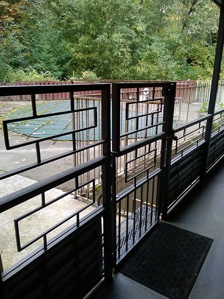 A balcony with a black railing and a black mat on the floor.