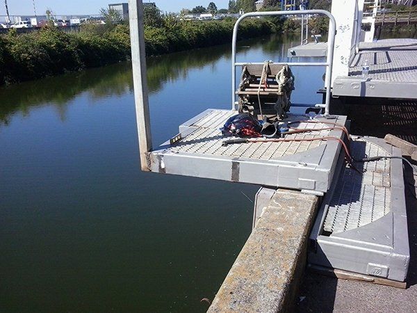 A boat is docked on a dock next to a river