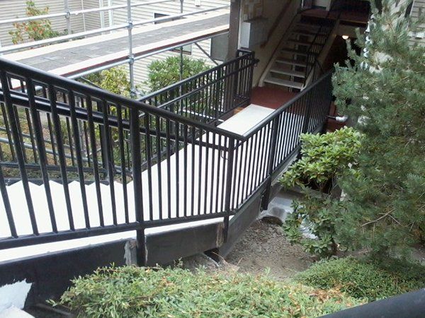 A set of stairs with a black railing leading up to them