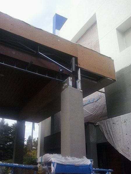 A building under construction with a blue crane in front of it