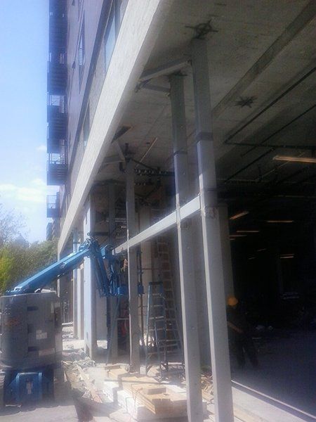 A building under construction with a crane on the side of it.