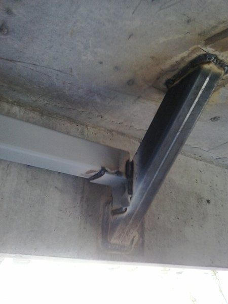 A close up of a metal beam attached to a concrete wall.