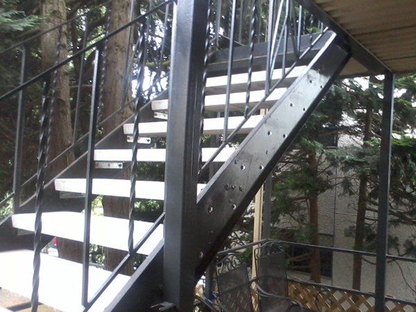 A set of stairs leading up to a balcony with trees in the background