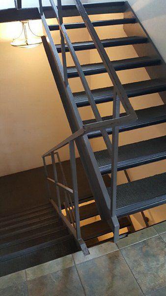 A staircase with a metal railing leading up to the second floor
