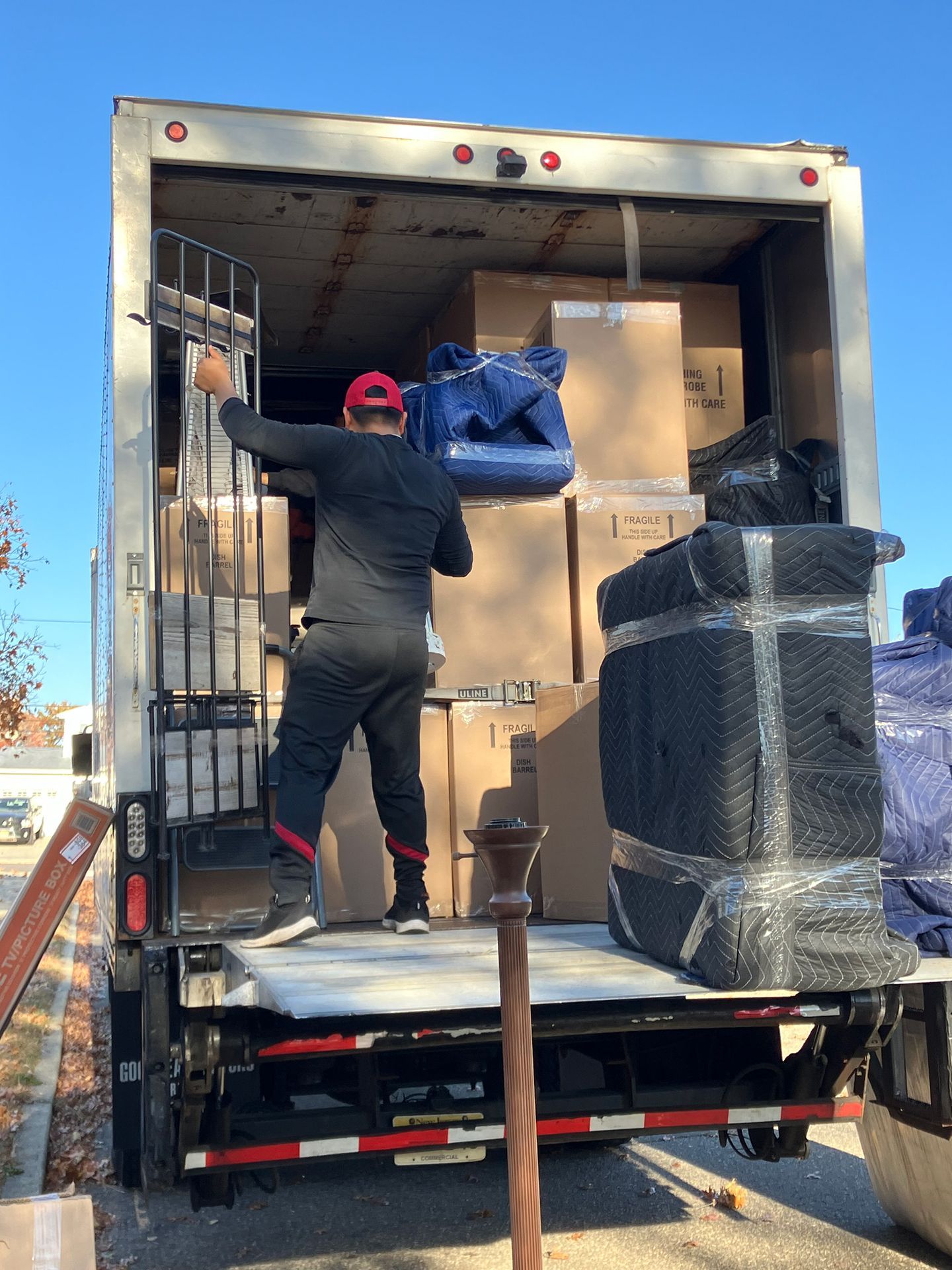 A man is loading boxes into a moving truck.