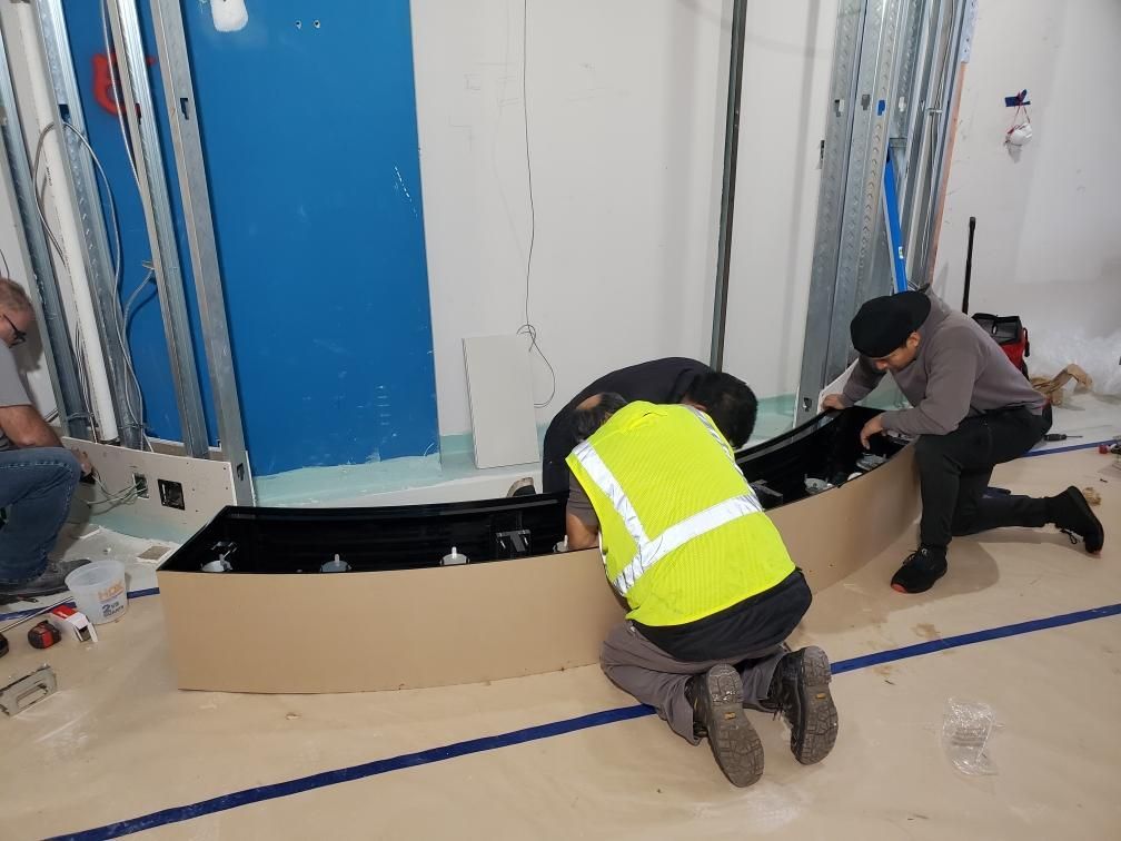 A group of construction workers are working on a box on the floor.
