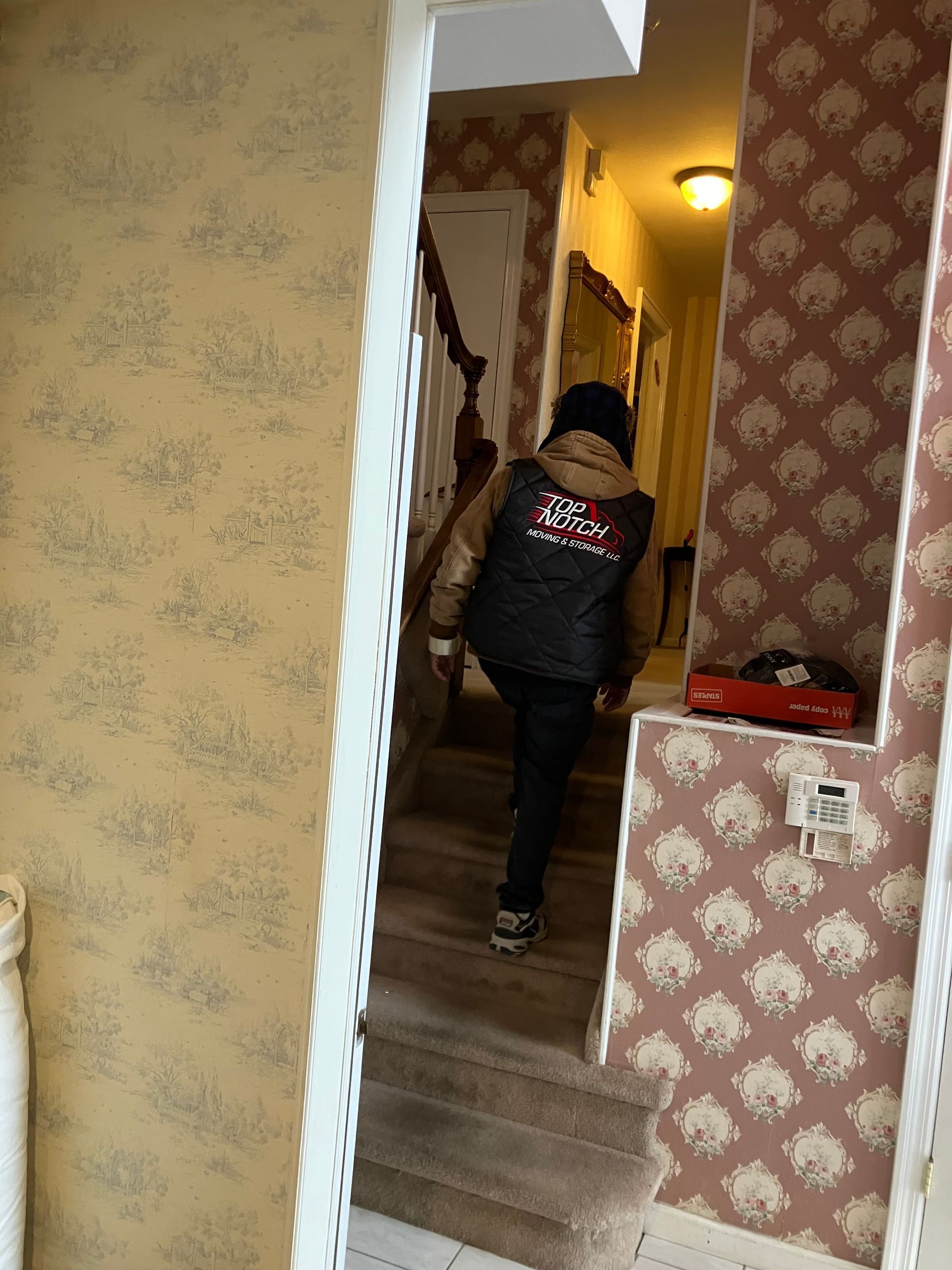 A man is walking down a set of stairs in a house.