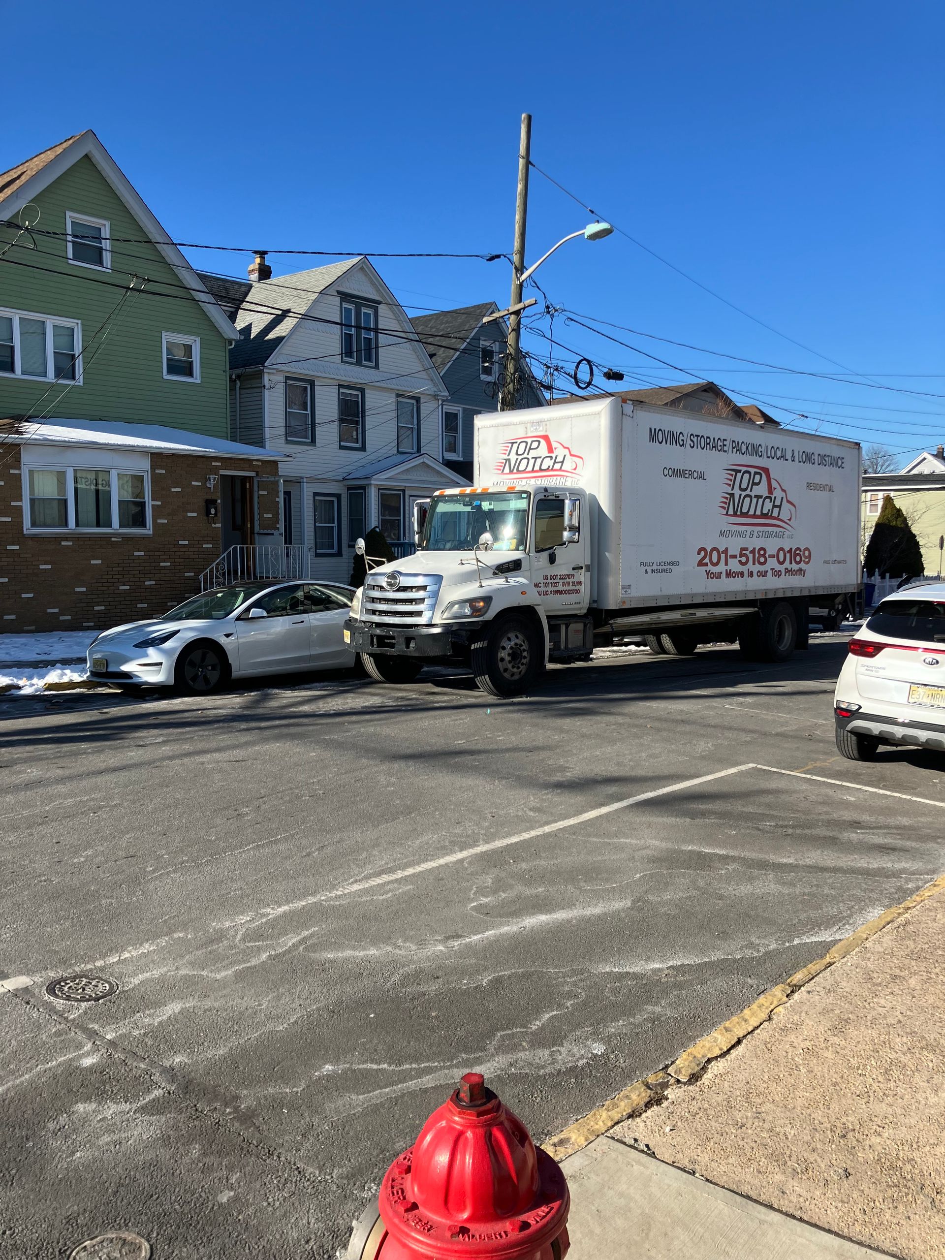 A white truck is parked in a parking lot next to a fire hydrant.