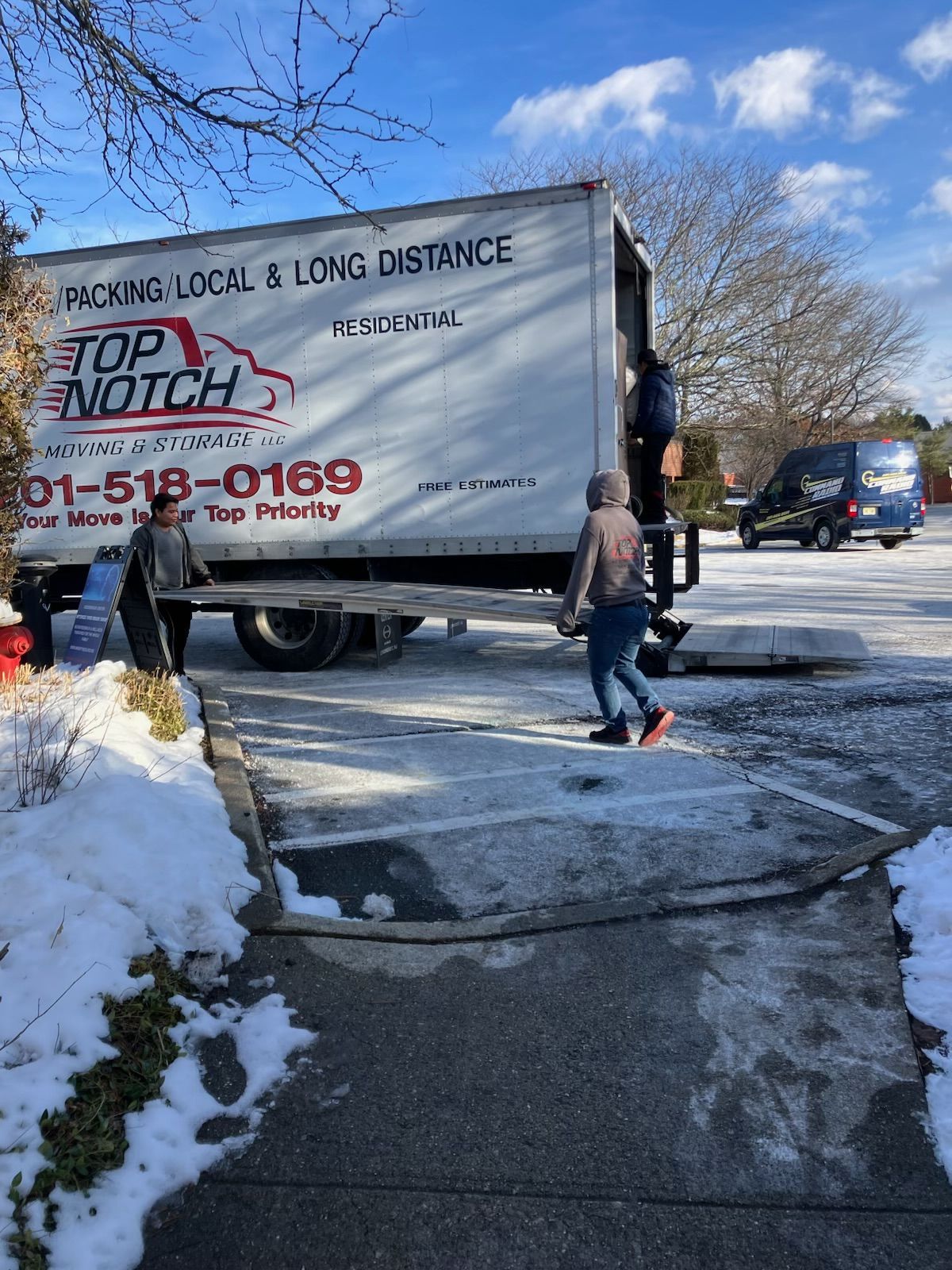 A man is walking in front of a top-notch moving truck.