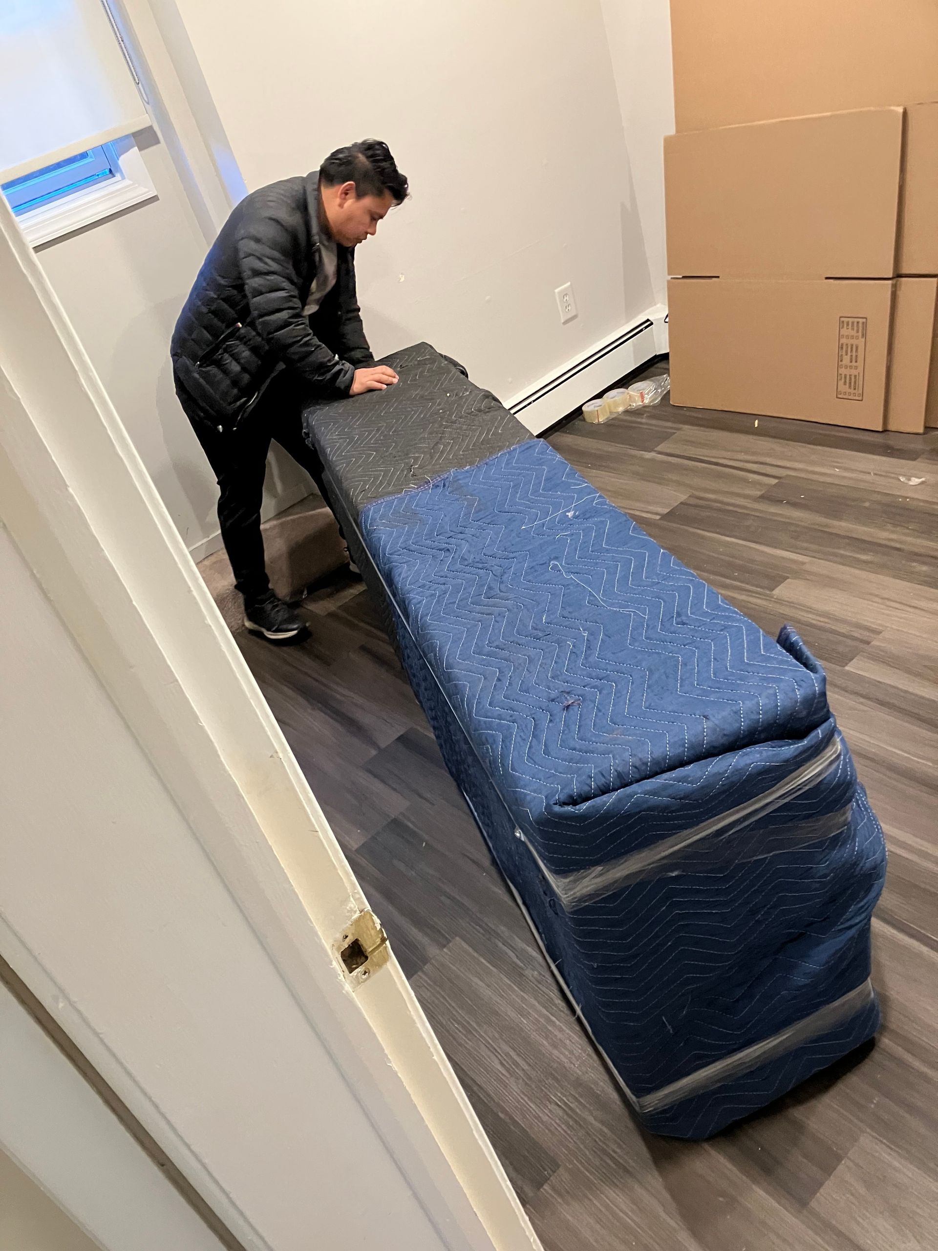 A man is moving a large piece of furniture in a room.