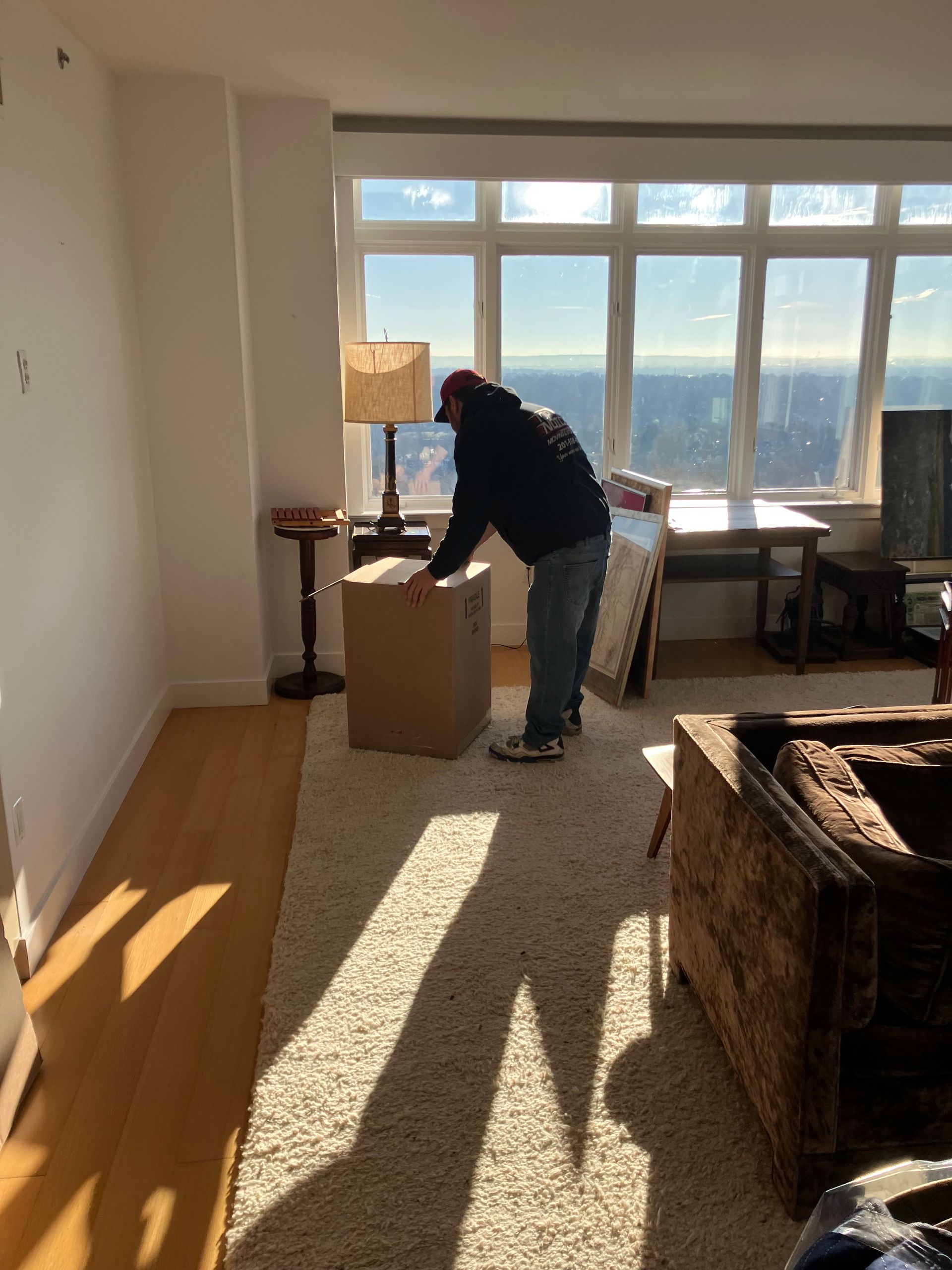 A man is packing a box in a living room