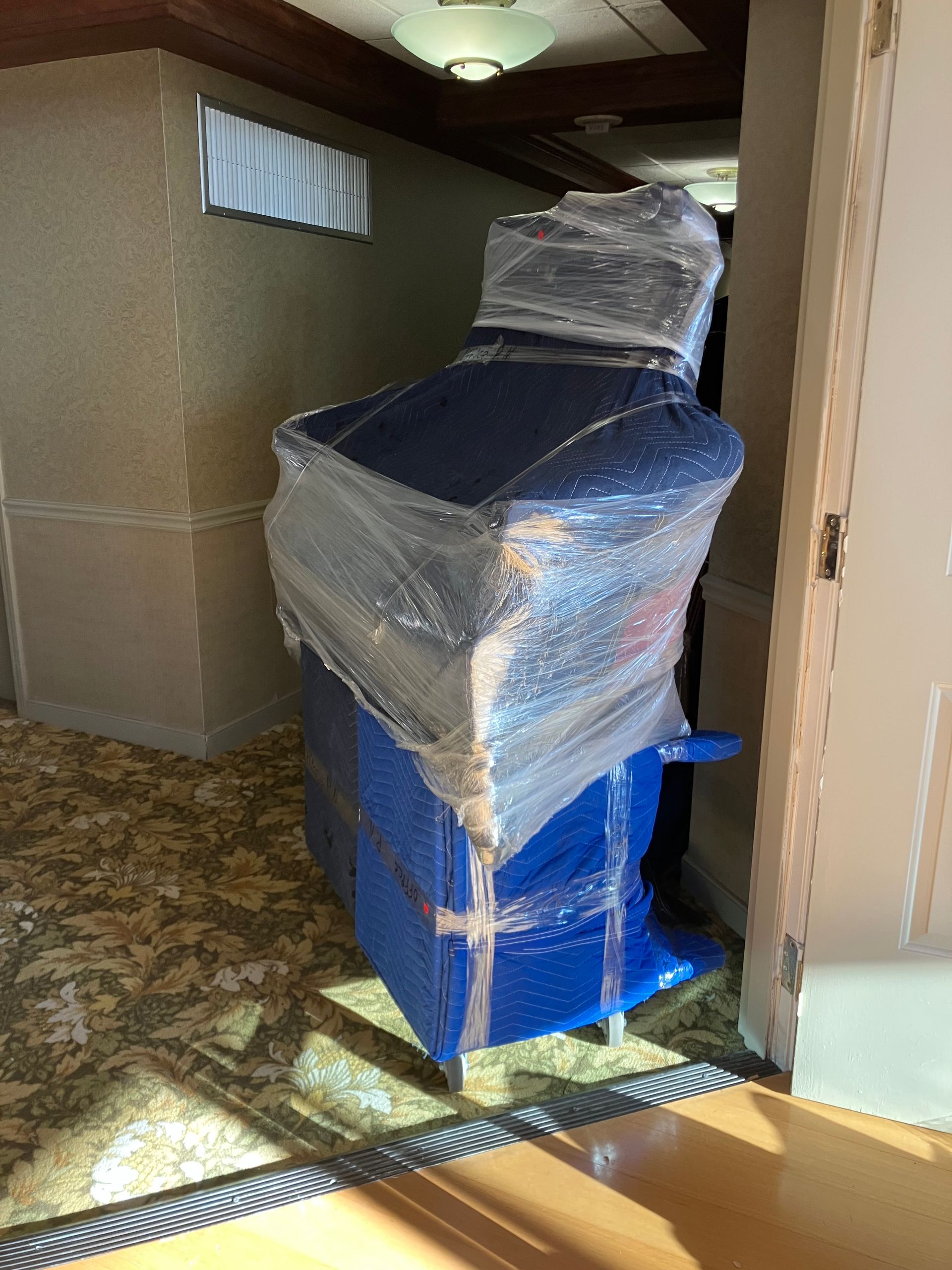 A blue box wrapped in plastic is sitting in a room.