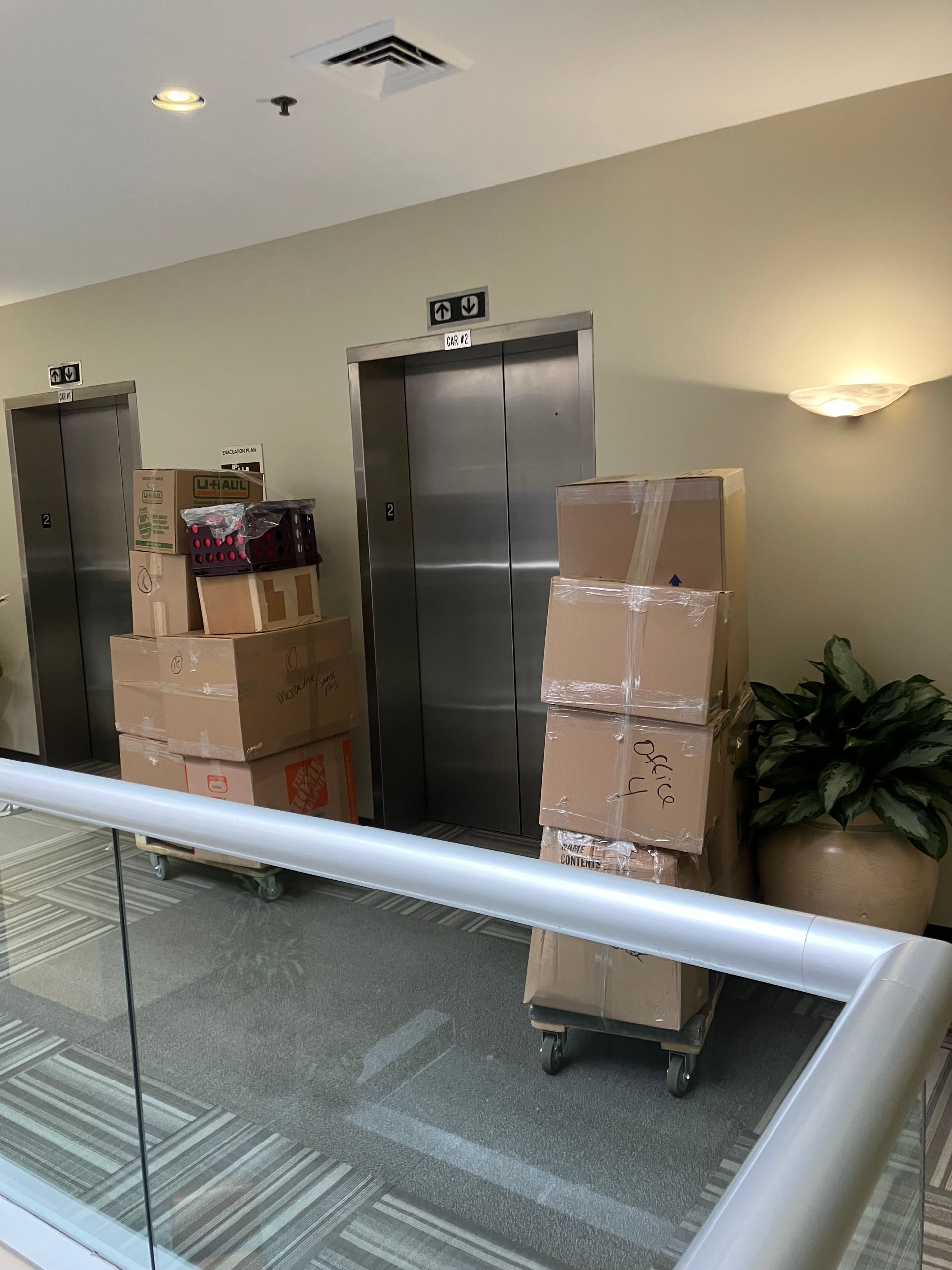A bunch of boxes are stacked on top of each other in front of an elevator.