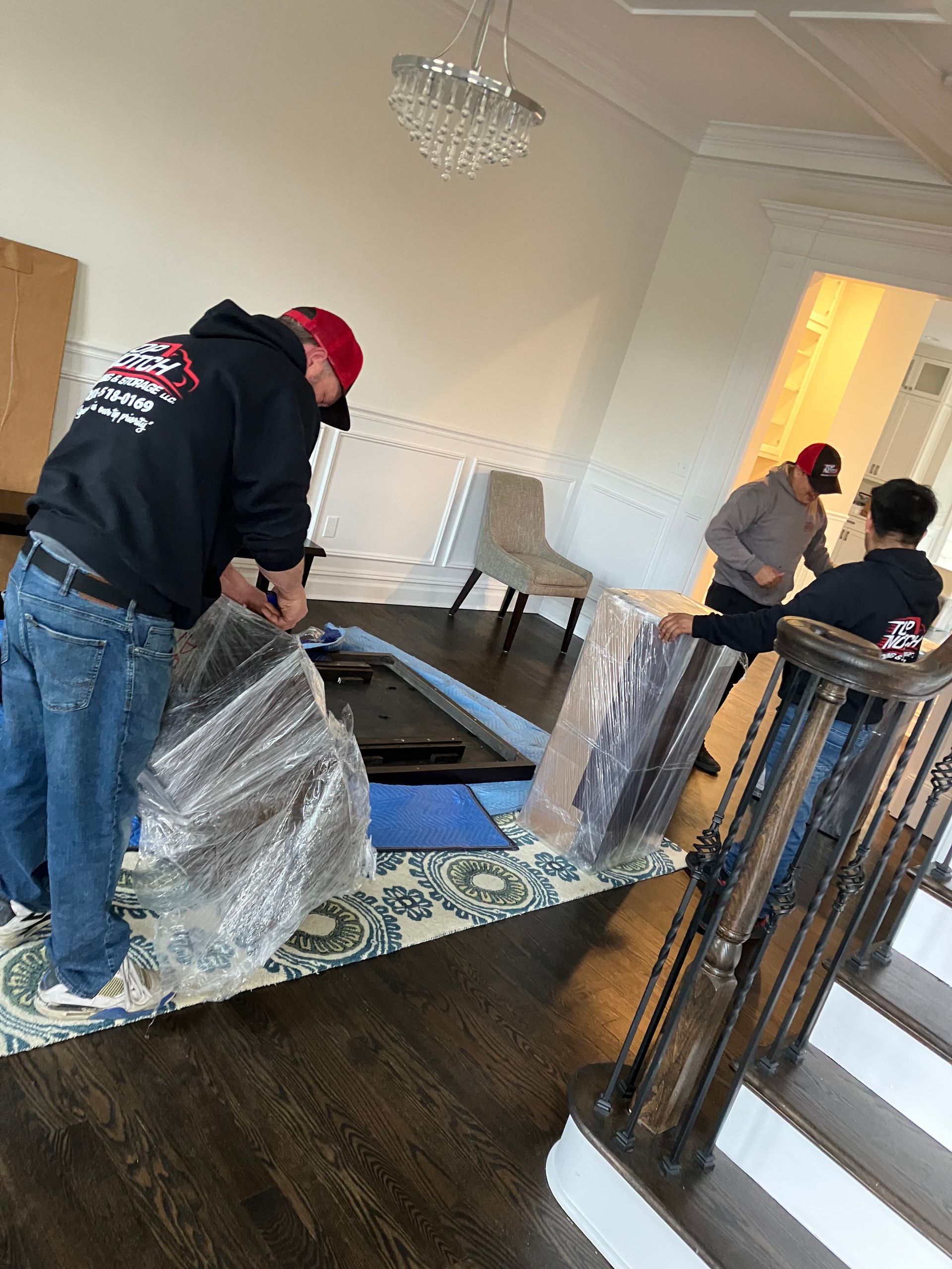 A group of men are moving furniture in a living room.