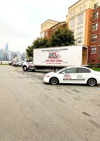 A white car is parked next to a white truck in a parking lot